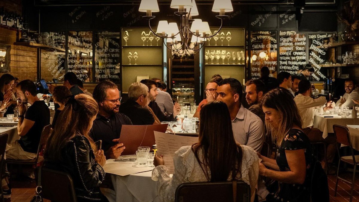 O Bistrot du Quartier é aconchegante e lembra os bistrôs parisienses, com sofás de veludo vermelho e toalhas de linho branco. O local serve pratos como a tradicional sopa de cebola, escargots com manteiga aromática, e o salmão com creme de azedinha. Foto: Divulgação