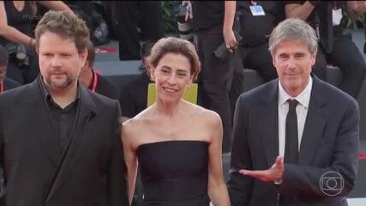 O filme estreou neste domingo (1º) no Festival de Cinema de Veneza. A plateia se emocionou e aplaudiu os diretores, atores e coordenadores por quase 10 minutos. Ao lado de Fernanda Torres, está o diretor Walter Salles e o ator Selton Mello. Foto: Reprodução/Globo