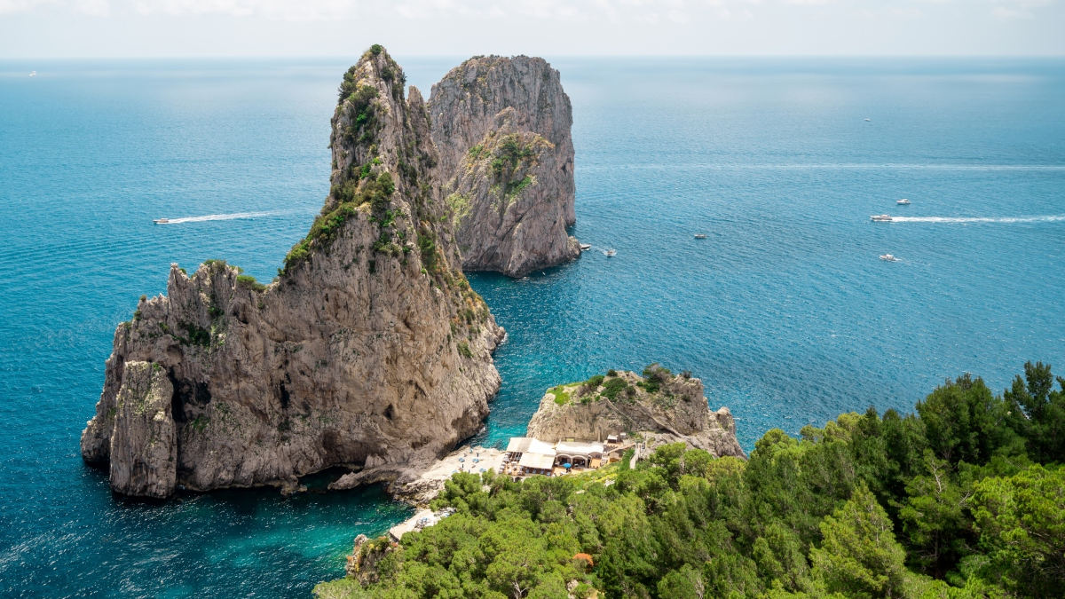 Capri, na Itália, encanta com sua praça pitoresca, relógios que badalam quando querem e vistas deslumbrantes do Vesúvio. Uma ilha onde o tempo parece parar, preservando seu charme atemporal. Foto: Freepik