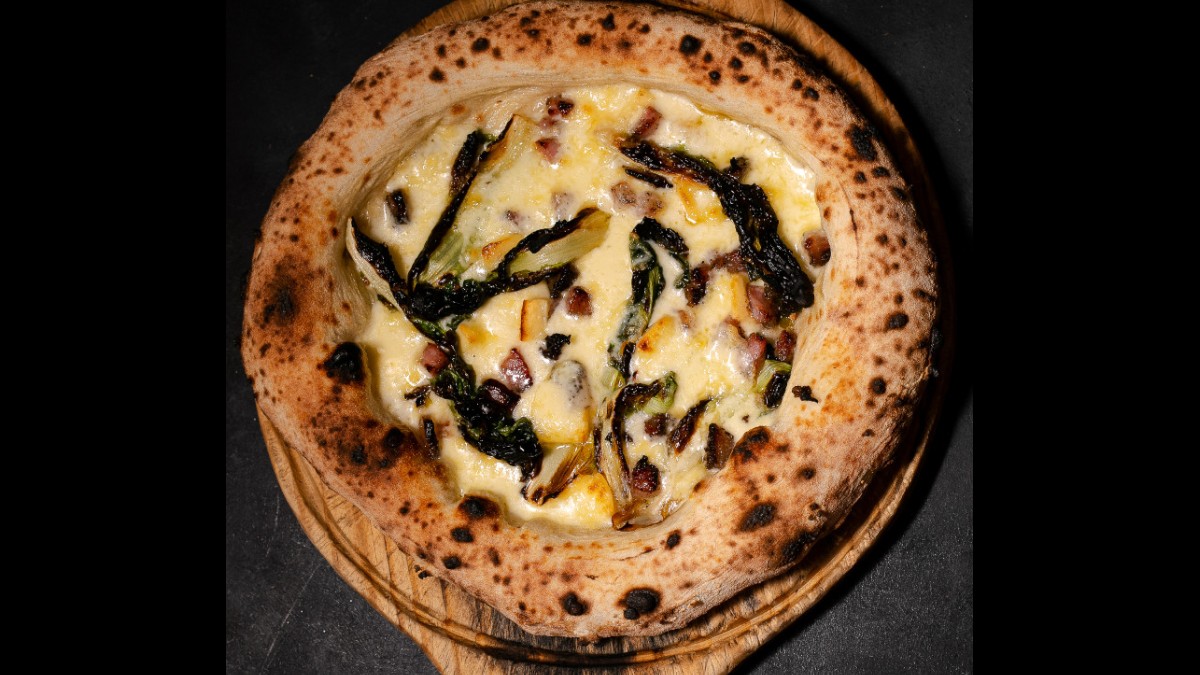 Pizza Amarga possui queijo mendes vermont, fior di latte, bacon e escarola. /Foto: Divulgação