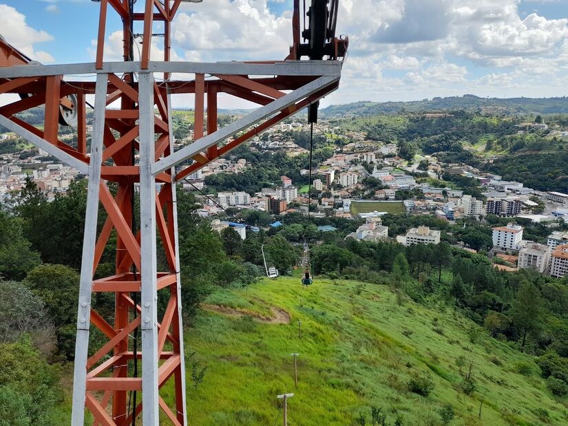 O teleférico de Serra Negra é a forma ideal de aproveitar para apreciar toda a beleza natural da região de uma forma divertida, além de ter uma vista panorâmica da cidade. O trajeto é feito em cadeirinhas individuais e dura cerca de 15 minutos até o Pico da Fonseca, onde está localizado o Cristo Redentor - (Reprodução)