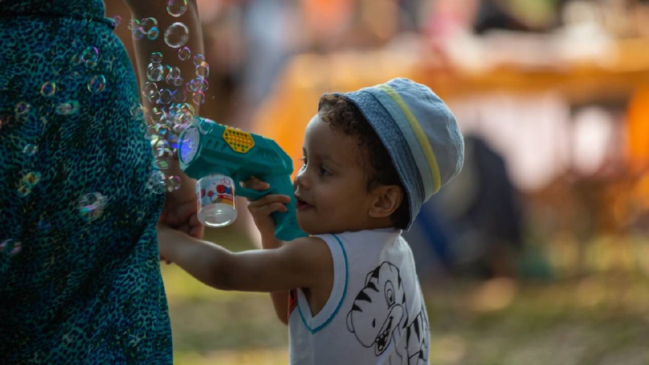 Criança brinca com bolhas de sabão ao lado da mãe. Foto: Divulgação