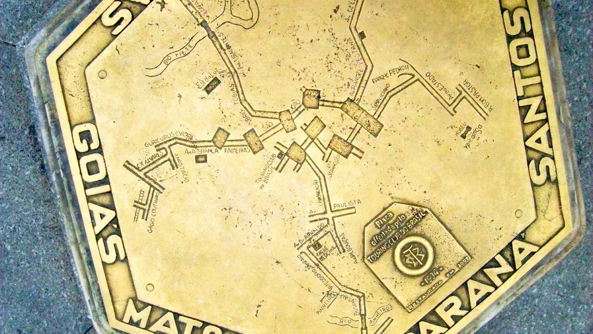 A placa atual é uma réplica da original, que foi roubada, mas a original apresentava pontos importantes da cidade da época, como os rios Tietê e Pinheiros, a Estação da Luz, a Faculdade de Medicina da USP, o Museu do Ipiranga (escrito como "Ypiranga") e vias como a Rua Voluntários da Pátria, a Rua da Consolação e a Avenida Paulista. Fotos: Wikimedia Commons