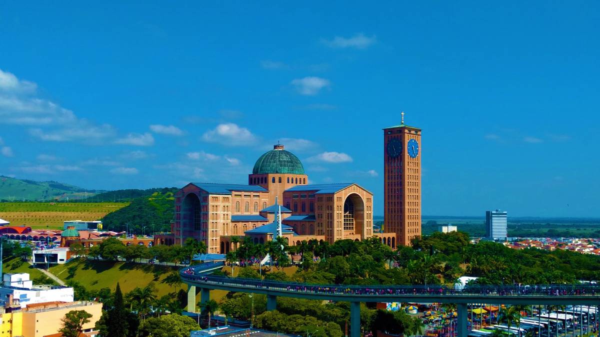Conhecida como Aparecida do Norte, a cidade é o principal destino religioso do país. A cerca de 170 km da capital, recebe milhões de fiéis todos os anos, atraídos pela Basílica de Nossa Senhora Aparecida o maior templo católico do mundo, com capacidade para 70 mil pessoas. A devoção começou no século XVIII, quando pescadores encontraram a imagem da santa no rio Paraíba do Sul. Desde então, Aparecida tornou-se sinônimo de fé e acolhimento. O complexo do santuário conta com museus, mirantes, aquário e até passeio de bondinho. Com boa infraestrutura e clima ameno, a cidade é também ponto de partida para explorar o Vale do Paraíba e o sul fluminense.