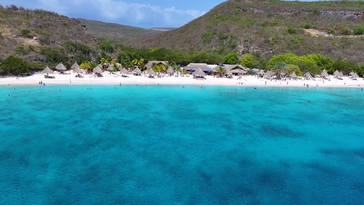 Agora em destaque devido ao seu sucesso no mundo do futebol, Curaçao é considerado um paraíso caribenho, com praias de águas cristalinas, arquitetura colorida em Willemstad, e um clima agradável fora da rota de furacões - (Reprodução/YouTube)