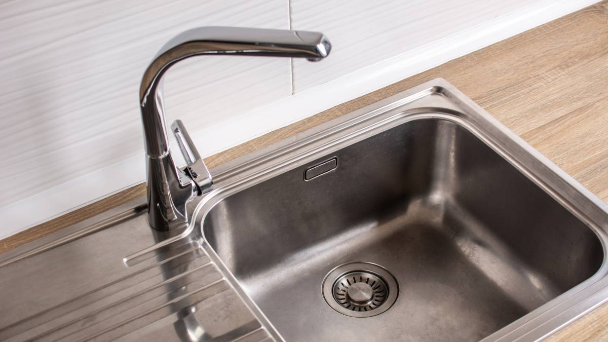 Lavanderia compacta com tanque de sobrepor otimiza o espaço em apartamentos pequenos.