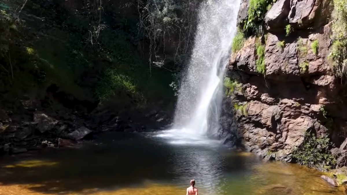 Um dos destaques do local é a Cachoeira Véu de Noiva, com seus impressionantes 86 metros de queda livre. O local permite observar a transição entre o Cerrado e a Amazônia, enquanto araras-vermelhas costumam sobrevoar os paredões rochosos - (Reprodução/YouTube Rolê Família)