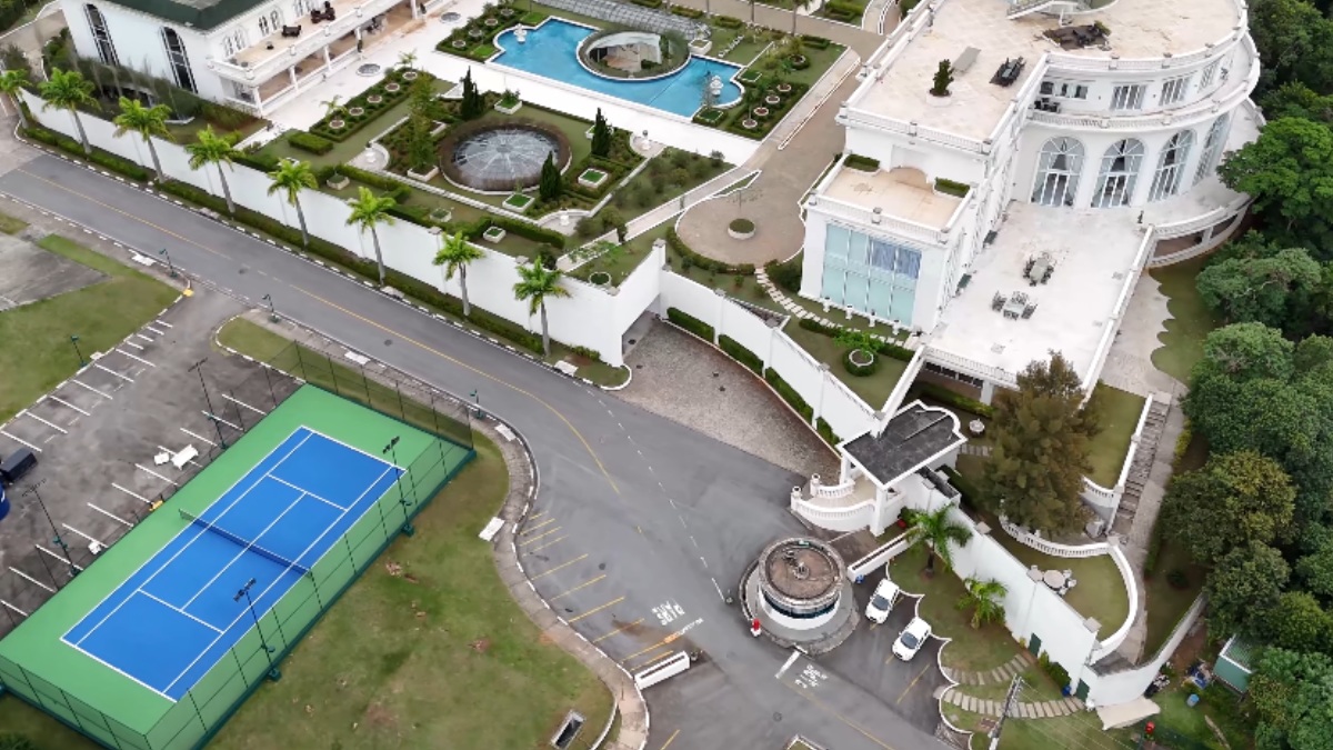Na parte exterior, o luxo continua, com várias múltiplas piscinas distribuídas pela propriedade. Uma quadra de tênis e uma sala de cinema para até 50 pessoas complementam as opções de entretenimento e lazer dentro do espaço - (Reprodução/YouTube Drone.v7)