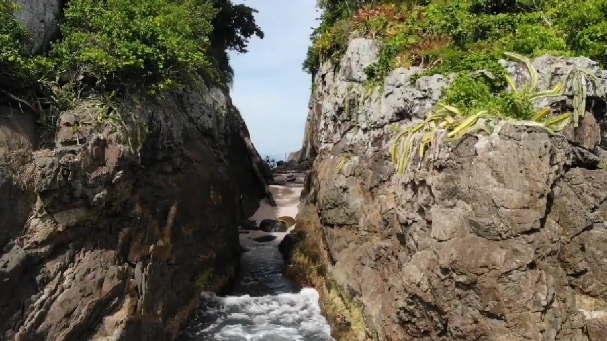 Na Ilha da Selinha, há uma pequena faixa de areia com 40 metros de extensão e pouco menos de cinco metros de largura entre as duas metades, o que justifica o título de menor praia do mundo - (Reprodução/YouTube/Caminhos do SUP)