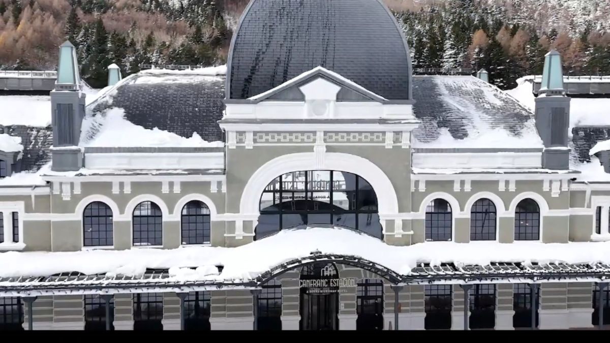 Onde o tempo fez uma parada: a grandiosa fachada da estação centenária agora protege o luxo contemporâneo no coração dos Pirineus. - Foto/Youtube