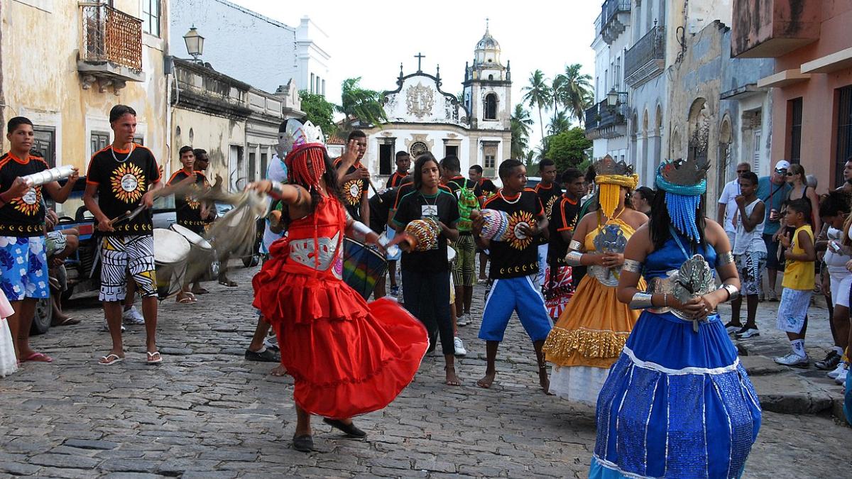 A festa atravessou séculos, absorveu costumes pagãos e regras do calendário cristão, até encontrar no Brasil um território onde dança e música passaram a ocupar papel central (Foto: Prefeitura de Olinda/Wikimedia Commons)