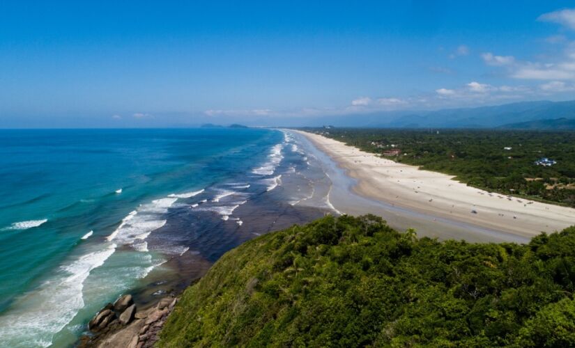 A praia de Guaratuba, em Bertioga, é conhecida pelo visual mais natural e por trechos com água mais clara, o que deixa o passeio com cara de litoral norte mesmo estando relativamente perto da capital. é uma boa para quem curte caminhar, observar a paisagem e aproveitar um dia de praia com um ritmo mais calmo, longe do centrão mais lotado. Foto: Prefeitura do Guarujá