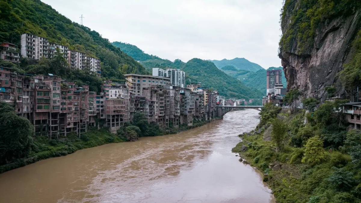 Uma cidade inteira espremida entre montanhas íngremes e um rio caudaloso (Foto: ダモ リ/@darmau/Unsplash)