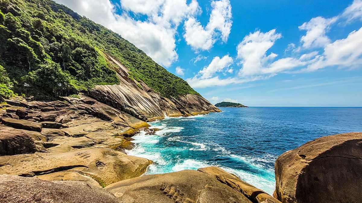O principal atrativo é nadar na piscina natural com vista aberta para o mar; também dá para observar o encontro do rio com o oceano e registrar fotos do cenário (Foto: João Paulo Marques D'Andretta/Wikimedia Commons)