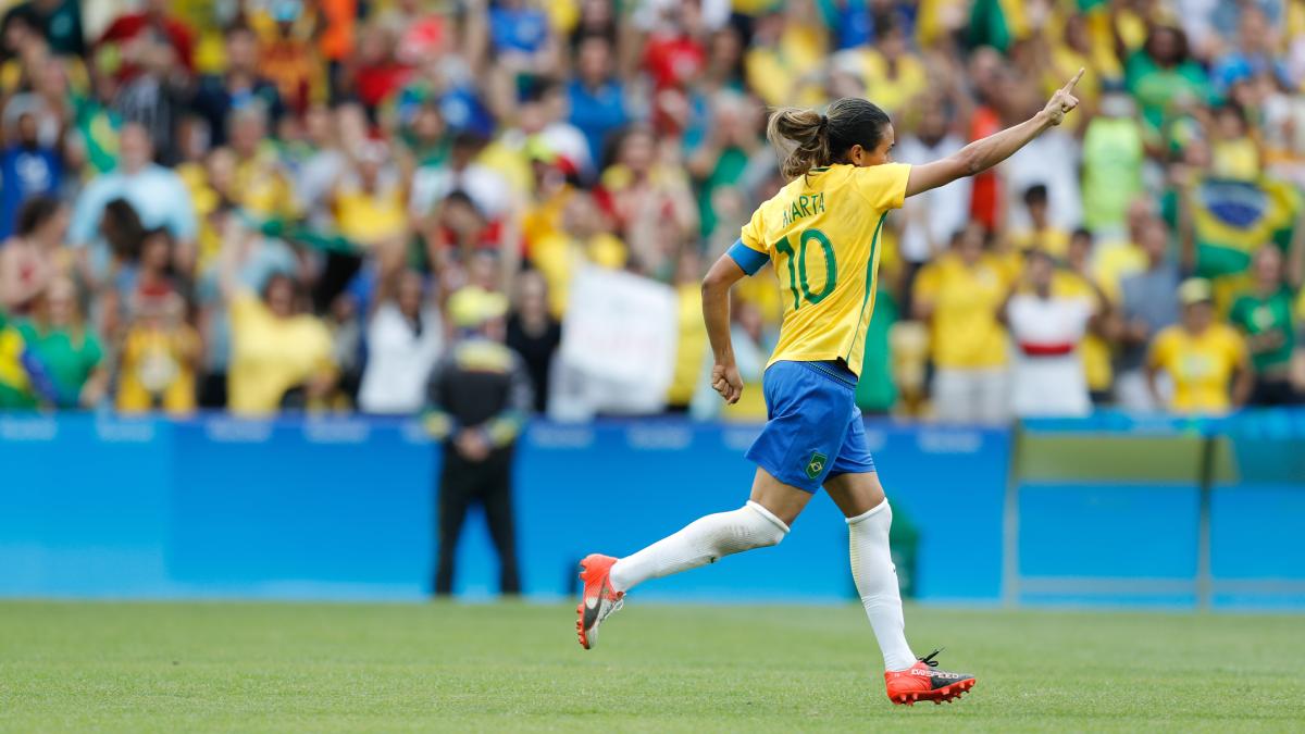 Aos 40 anos, segue em alto nível, símbolo de resistência, talento e inspiração para gerações que cresceram acreditando que lugar de mulher também é no topo do futebol. Fotos: Wikimedia Commons.