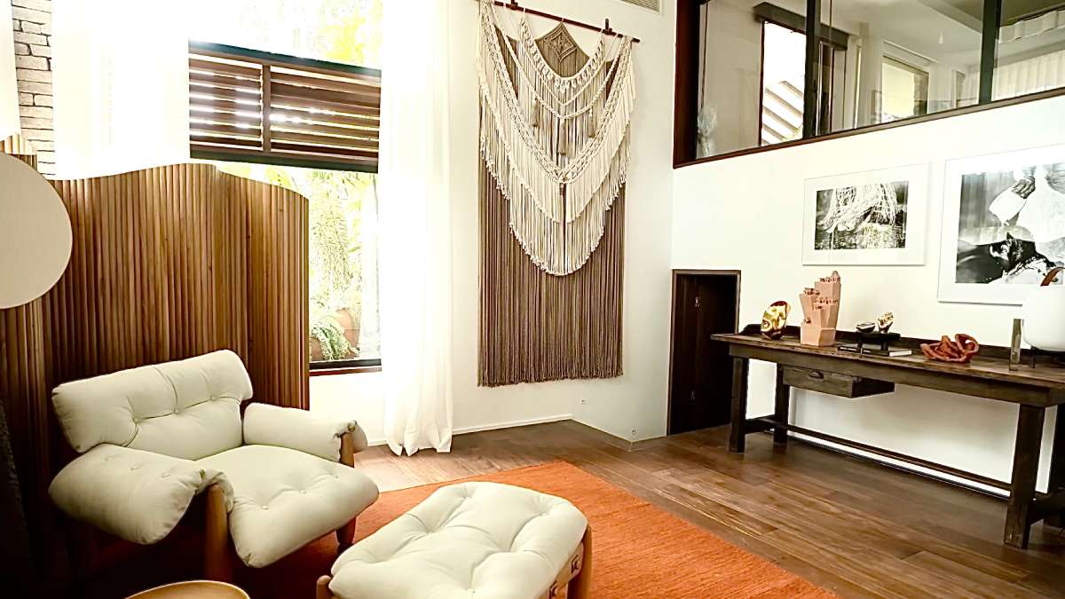 7. A sala de estar possui um cantinho relaxante para leitura, adornado com uma bela escultura de pescador. Foto: Reprodução/Youtube