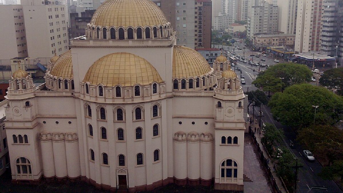 O contraste entre cúpulas douradas e prédios altos do bairro ajuda a explicar por que a fachada chama tanta atenção ao vivo (Foto: Ana Paula Hirama / Wikimedia Commons)