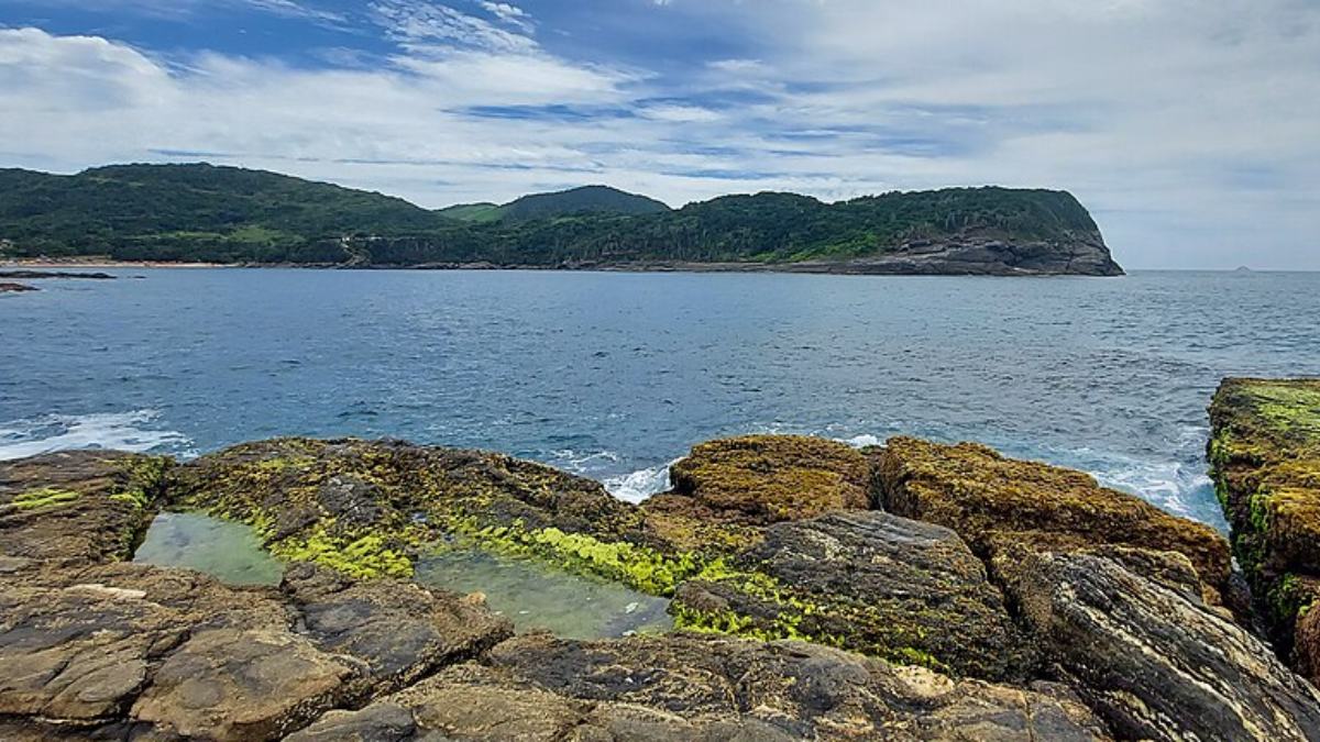 O que realmente chama atenção são as piscinas naturais que se formam entre pedras escuras de origem vulcânica, criando pequenos espelhos de água transparente