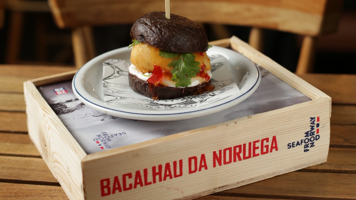 Bao de tempurá de Bacalhau da Noruega com açaí, sweet chilli, picles de chuchu e coentro