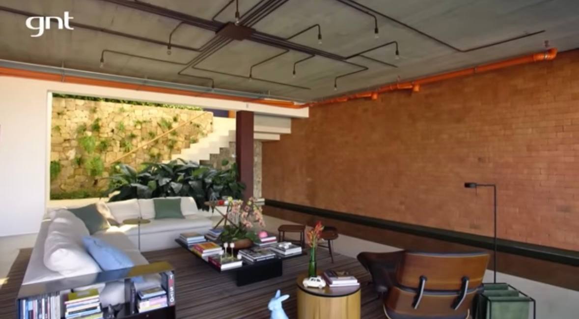 O ponto mais icônico da casa é a piscina que atravessa a área social e conecta o interior ao exterior /Reprodução/Youtube