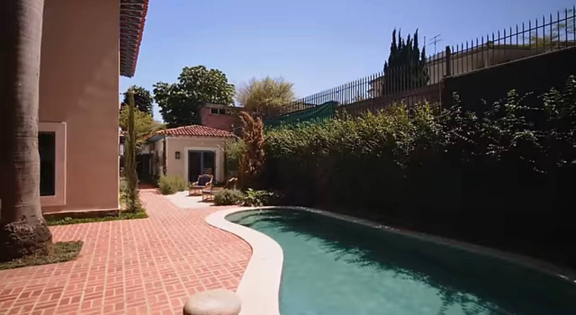 A área externa abriga uma piscina de raia, cercada por vegetação densa que garante privacidade total aos moradores /Reprodução/Youtube