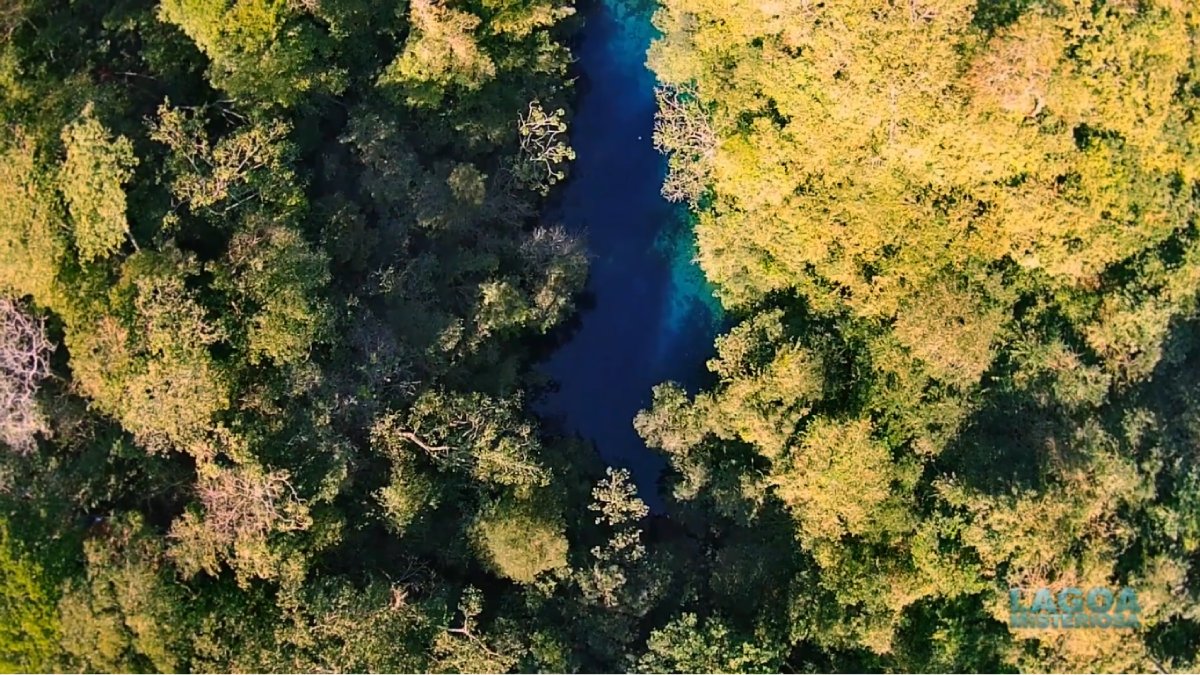 O acesso inclui trilha pela mata, mirante e uma escadaria que leva ao deque sobre a lagoa