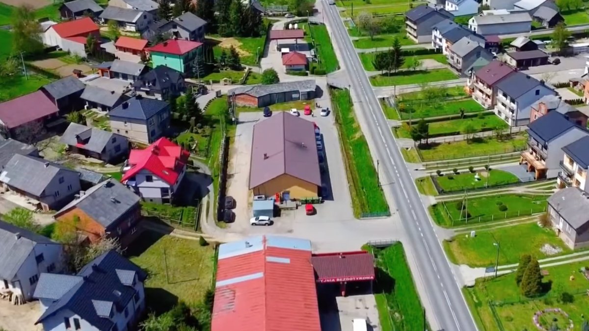 As casas se distribuem ao longo de uma única via, com campos agrícolas estreitos atrás delas. Foto: Reprodução/Youtube