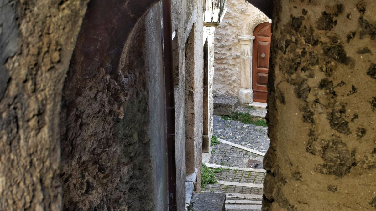 Portões, muros e fachadas de pedra reforçam o peso histórico dessas comunidades, que tentam continuar habitadas além da temporada turística (Foto: Pexels)